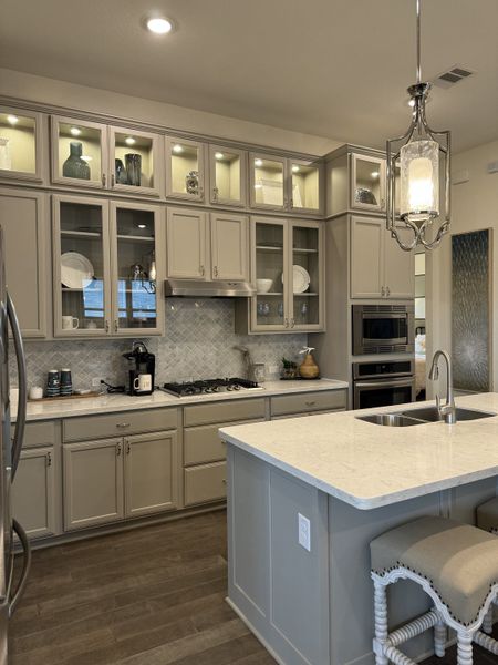Elegant kitchen with glass-front cabinets, a marble island, and modern lighting creating a cozy yet sophisticated space. Elegant kitchen with glass-front cabinets, a marble island, and modern lighting creating a cozy yet sophisticated space.
