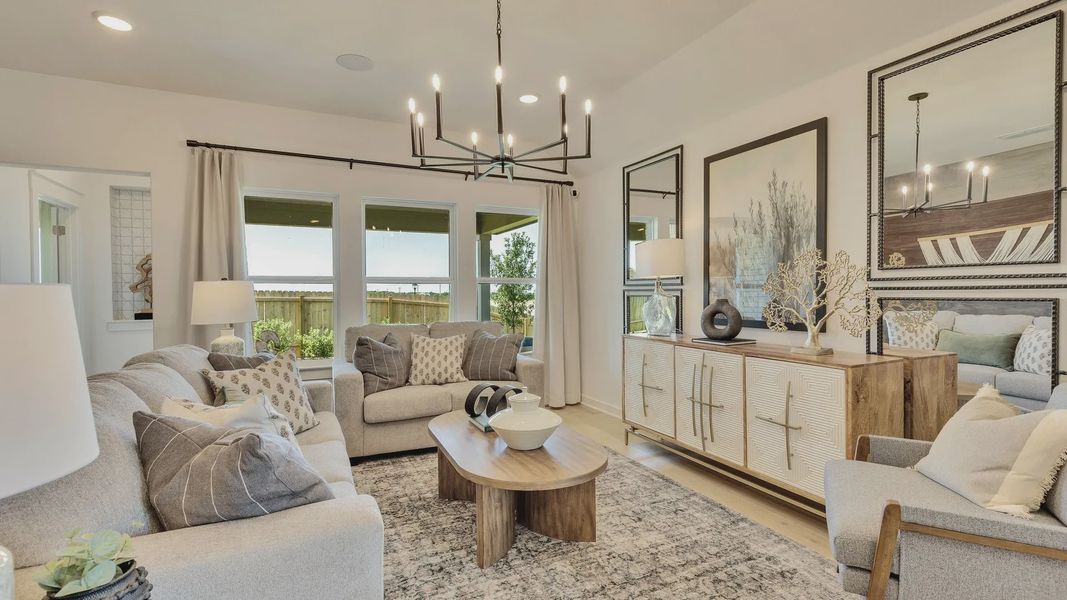 Bright living room adorned with sleek chandelier and chic furnishings in Hunters Glen. Bright living room adorned with sleek chandelier and chic furnishings in Hunters Glen.