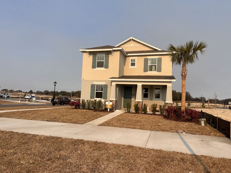 A stunning model home exterior with craftsman-style architecture and a welcoming porch in Crossroads at Kelly Park by Dream Finders Homes (Apopka, FL).