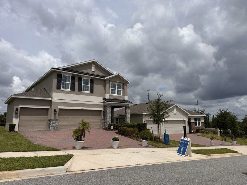 Elegant two-story home with brick accents in Ridgeview by Landsea Homes, Clermont, FL. Quiet neighborhood setting.