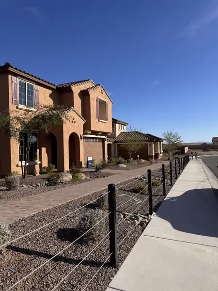 A beautiful stucco home with rustic shutters and desert landscaping in Aloravita by Pulte Homes (Peoria, AZ).