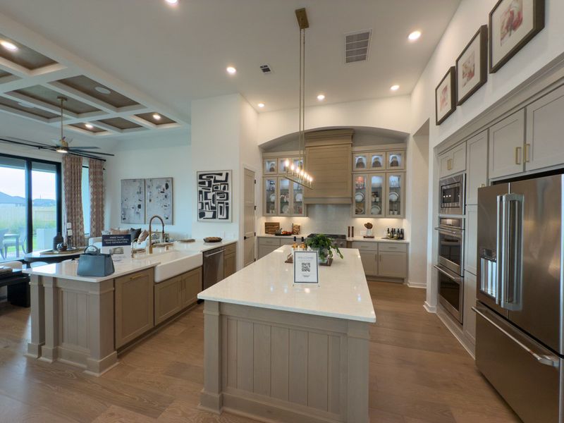 A spacious kitchen featuring a large island, elegant cabinetry, stainless steel appliances, and modern lighting. A spacious kitchen featuring a large island, elegant cabinetry, stainless steel appliances, and modern lighting.