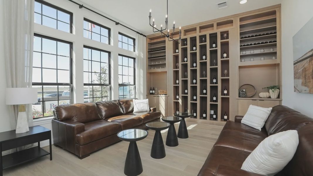Elegant Brookewater living room features expansive windows, bespoke wine display, and refined leather furnishings. Elegant Brookewater living room features expansive windows, bespoke wine display, and refined leather furnishings.