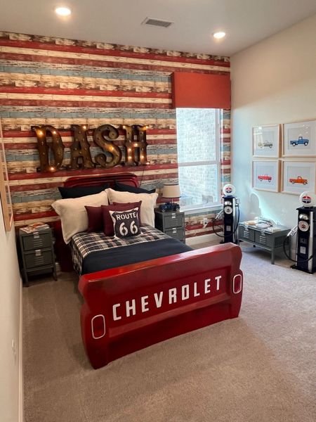 A vibrant kids' room with a Chevrolet-themed bed, Route 66 decor, and vintage car artwork. A vibrant kids' room with a Chevrolet-themed bed, Route 66 decor, and vintage car artwork.