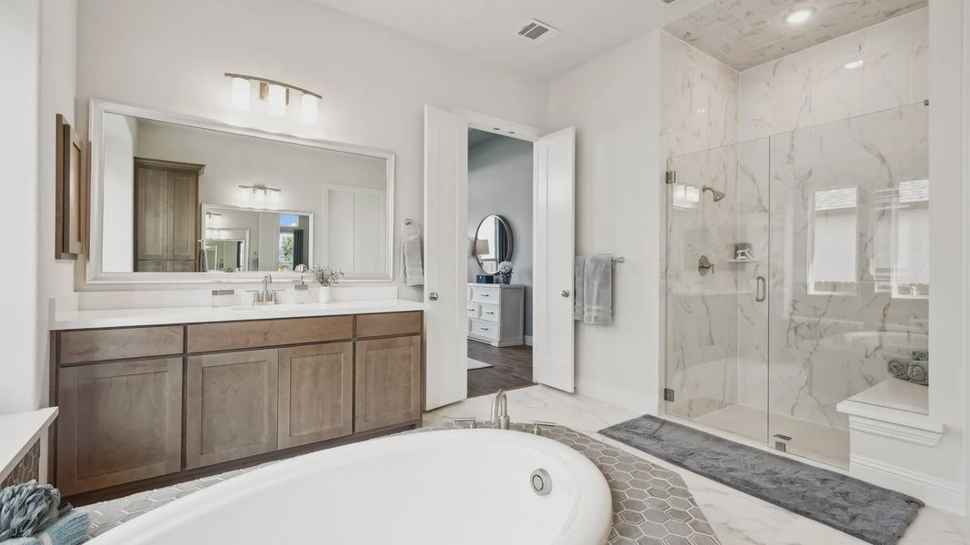 Experience opulence with a marble shower, freestanding tub, and bespoke vanity in Ridge Crossing. Experience opulence with a marble shower, freestanding tub, and bespoke vanity in Ridge Crossing.