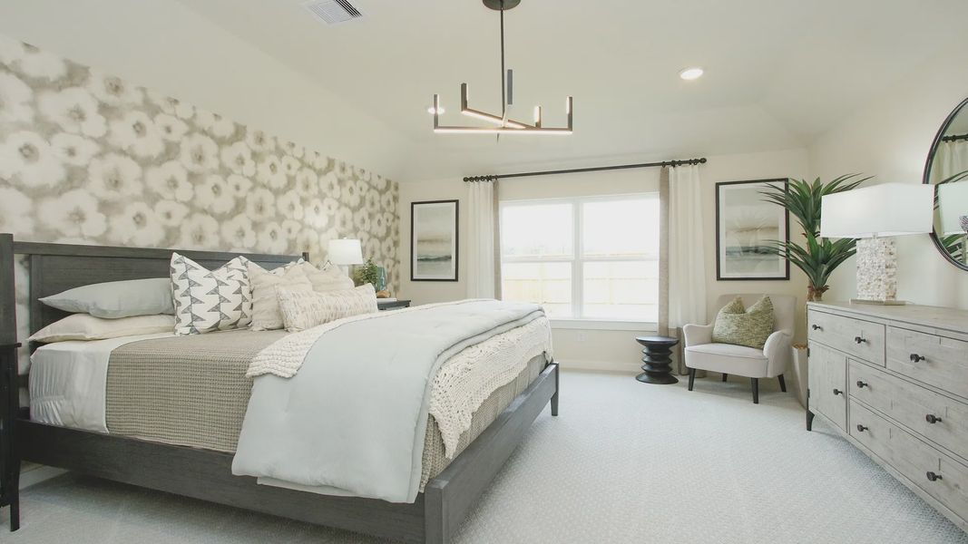 Embrace luxury with chic lighting and a bold accent wall in Colony at Pinehurst's serene bedroom.