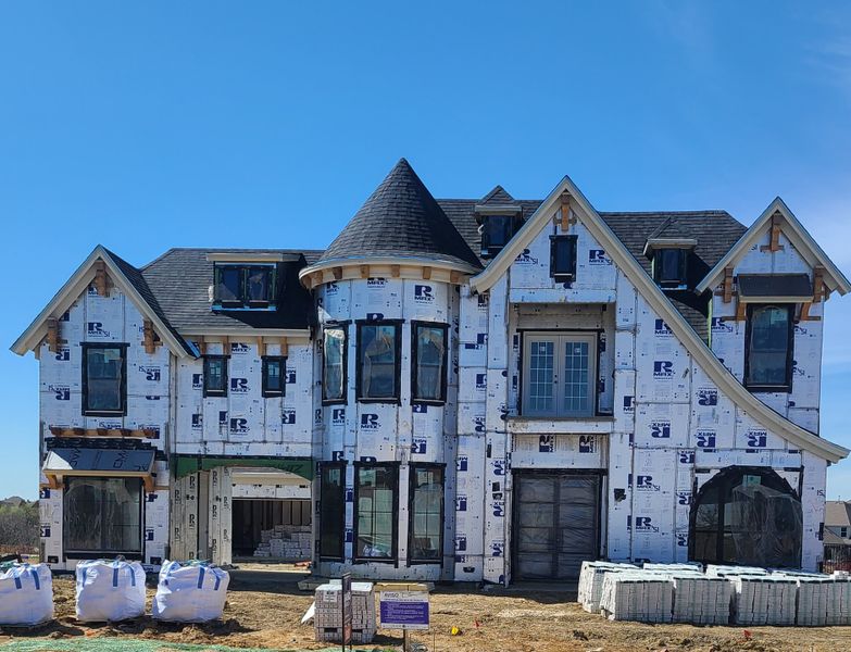 A grand under-construction home with turret and multiple gables in Silverleaf Estates by Grand Homes (Frisco, TX).