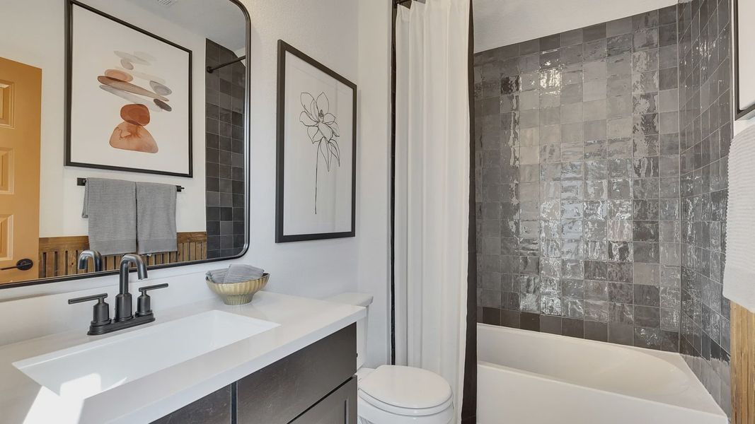 Elegant dark tile complements minimalist fixtures in Spring Creek's upscale bathroom.