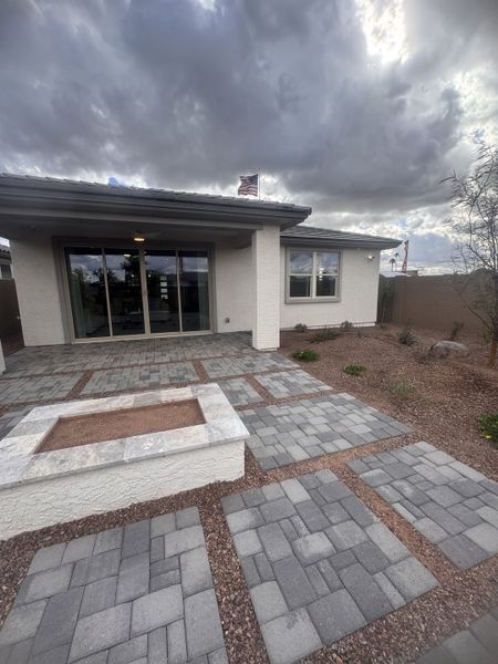 A modern home with a sleek patio and stone pathways in Seasons at Trevino by Richmond American Homes (Glendale, AZ).