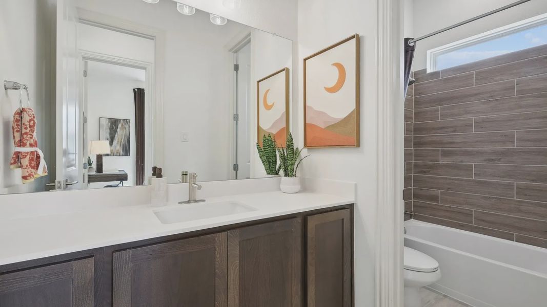 Luxurious dark wood cabinetry and exquisite wood-tiled shower enhance this Heritage Park bathroom.