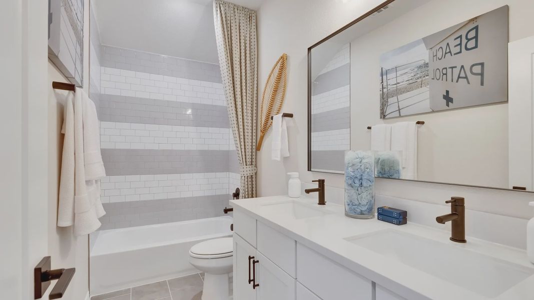 Luxurious double vanity with sleek bronze fixtures and designer subway tiles in Sunfield's upscale bathroom. Luxurious double vanity with sleek bronze fixtures and designer subway tiles in Sunfield's upscale bathroom.