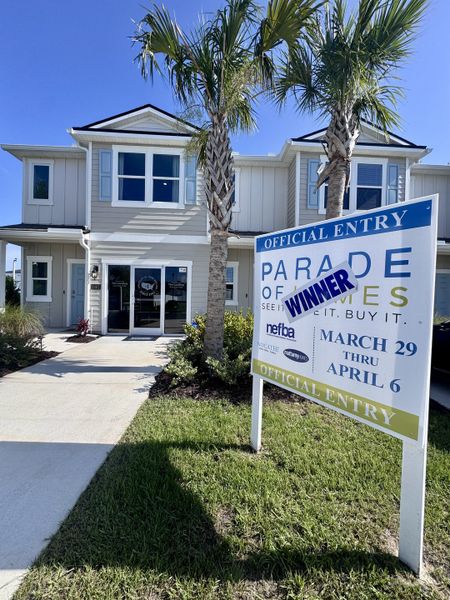 A chic townhouse with palm trees and a welcoming entrance in The Landing by D.R. Horton (Middleburg, FL).