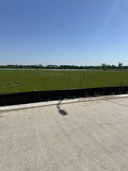 Open grassy field under a clear blue sky in Crosby Farms by Lennar (Crosby, TX).