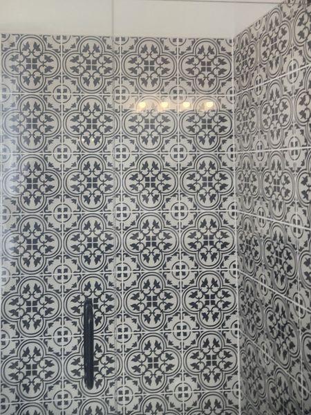 An elegant bathroom with patterned black and white tiles creating a stylish and sophisticated atmosphere. An elegant bathroom with patterned black and white tiles creating a stylish and sophisticated atmosphere.
