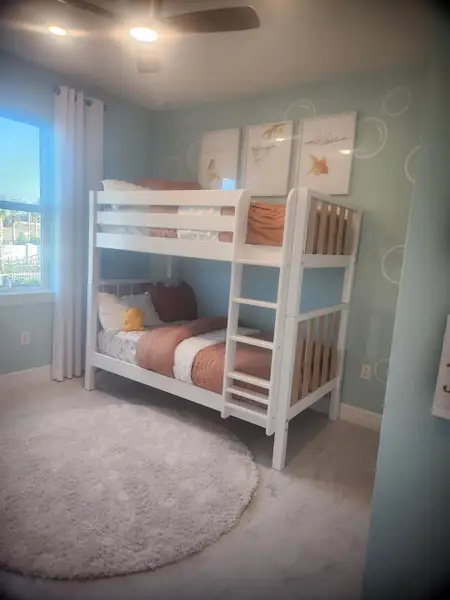 A whimsical kids’ bedroom with an ocean-inspired theme, pastel hues, and bunk beds in Panther Creek by KB Home (Jacksonville, FL).