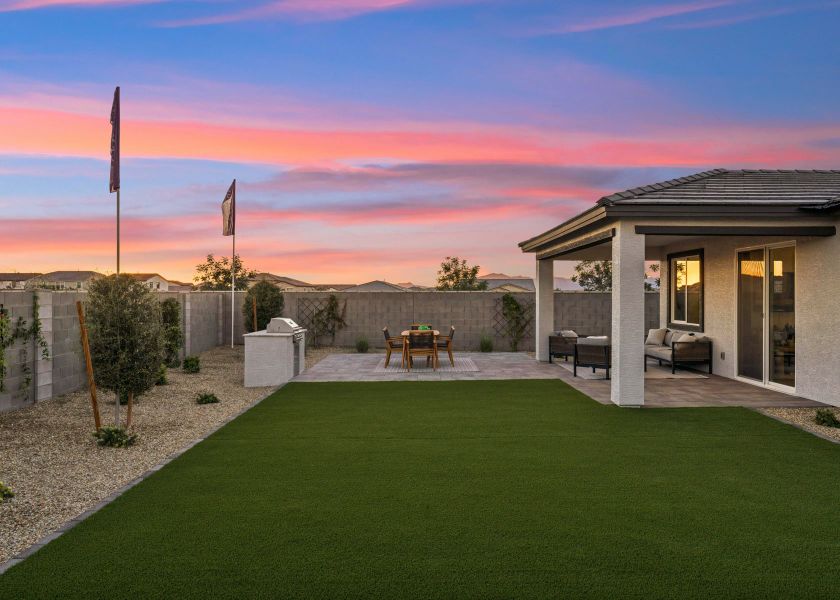 A building with a lawn and a table and chairs in the front.