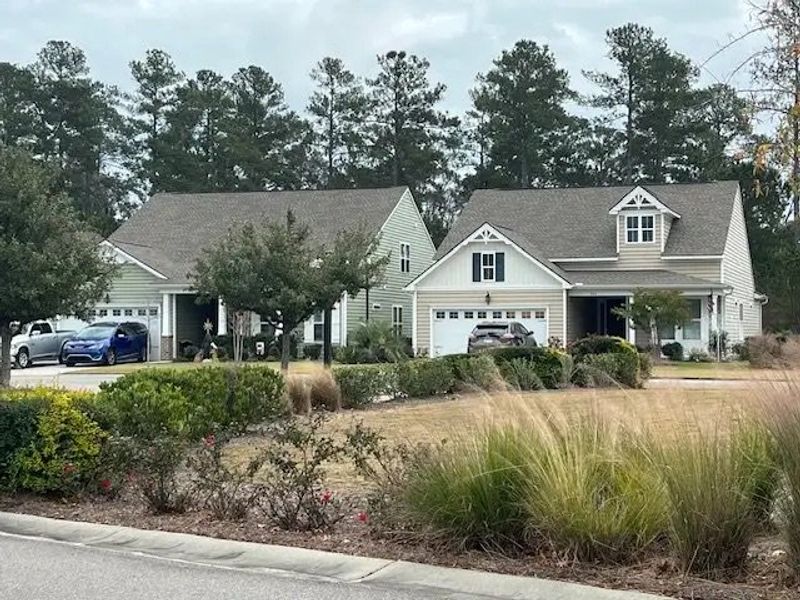 Two charming homes with manicured lawns in Four Seasons at Lakes of Cane Bay by K. Hovnanian® Homes (Summerville, SC).