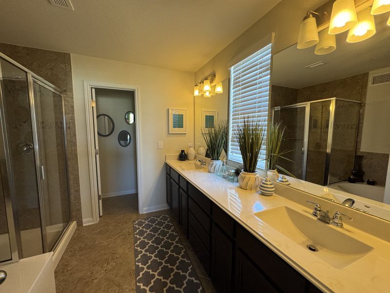 Elegant bathroom featuring double sinks, large mirror, stylish lighting, glass shower, and tasteful decor. Elegant bathroom featuring double sinks, large mirror, stylish lighting, glass shower, and tasteful decor.