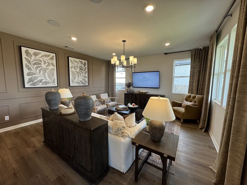 A cozy living room with wood floors, elegant decor, soft lighting, and large windows enhancing the space's warm atmosphere. A cozy living room with wood floors, elegant decor, soft lighting, and large windows enhancing the space's warm atmosphere.