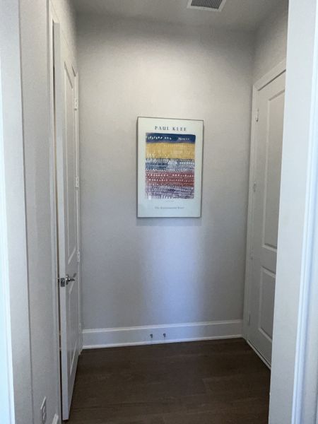 A minimalist hallway with light gray walls, wooden flooring, and a framed Paul Klee artwork. A minimalist hallway with light gray walls, wooden flooring, and a framed Paul Klee artwork.