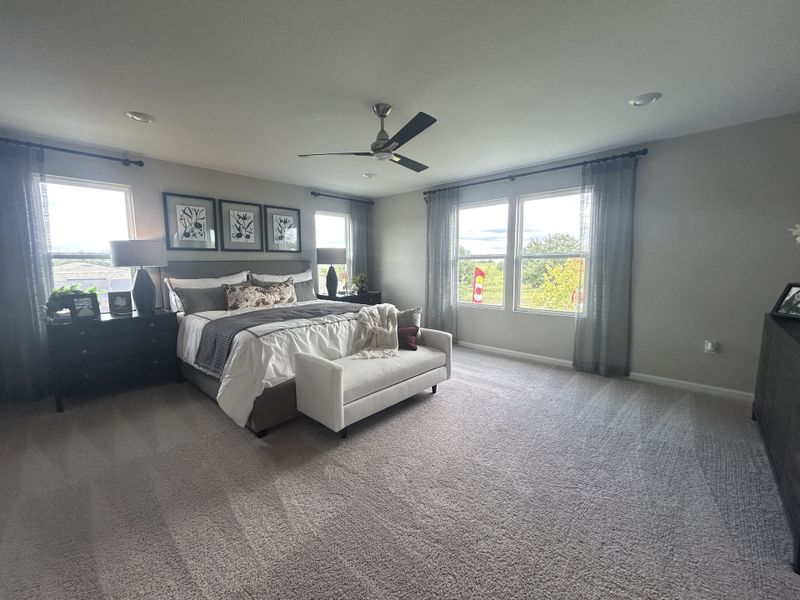 A spacious bedroom with modern decor, featuring a cozy bed, elegant wall art, and ample natural light through large windows. A spacious bedroom with modern decor, featuring a cozy bed, elegant wall art, and ample natural light through large windows.