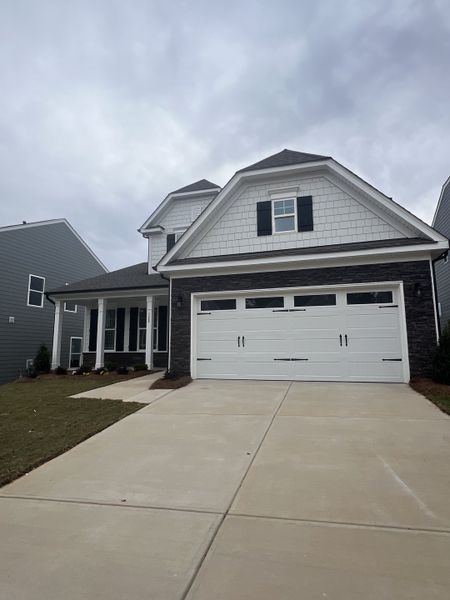 A charming home with a gabled roof and spacious driveway in Summerlin by Eastwood Homes (Mooresville, NC).