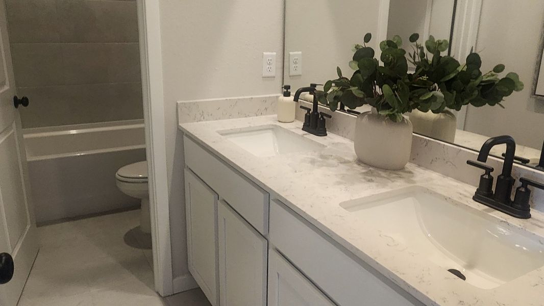 A modern bathroom featuring a dual-sink marble vanity and elegant matte black fixtures.