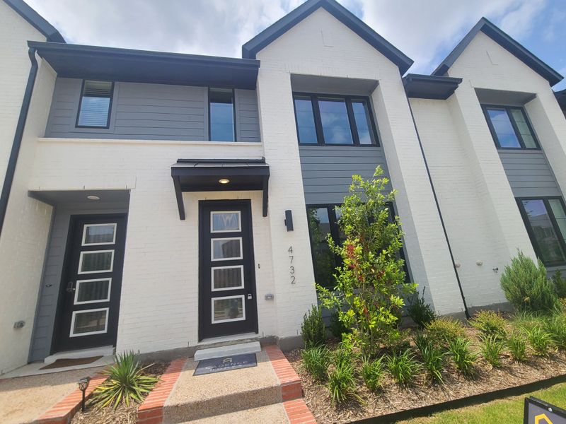 A modern townhouse with a sleek facade and landscaped entry in Viridian by Cadence Homes (Arlington, TX).