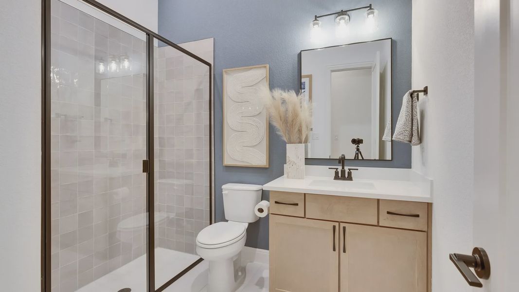 Elegant glass shower, stylish vanity with sleek fixtures in Spring Creek's refined atmosphere.