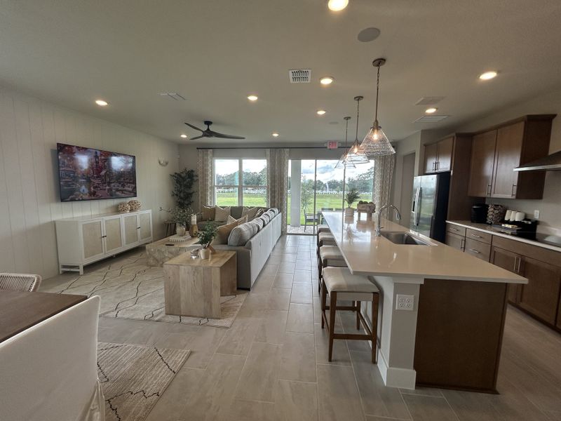 Spacious open-concept living area with elegant kitchen, modern furnishings, and serene outdoor view.