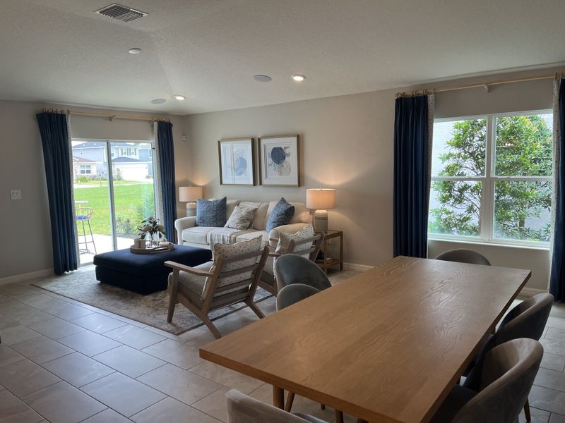 A cozy living and dining area with plush seating, natural light, and elegant curtains in a neutral palette. A cozy living and dining area with plush seating, natural light, and elegant curtains in a neutral palette.