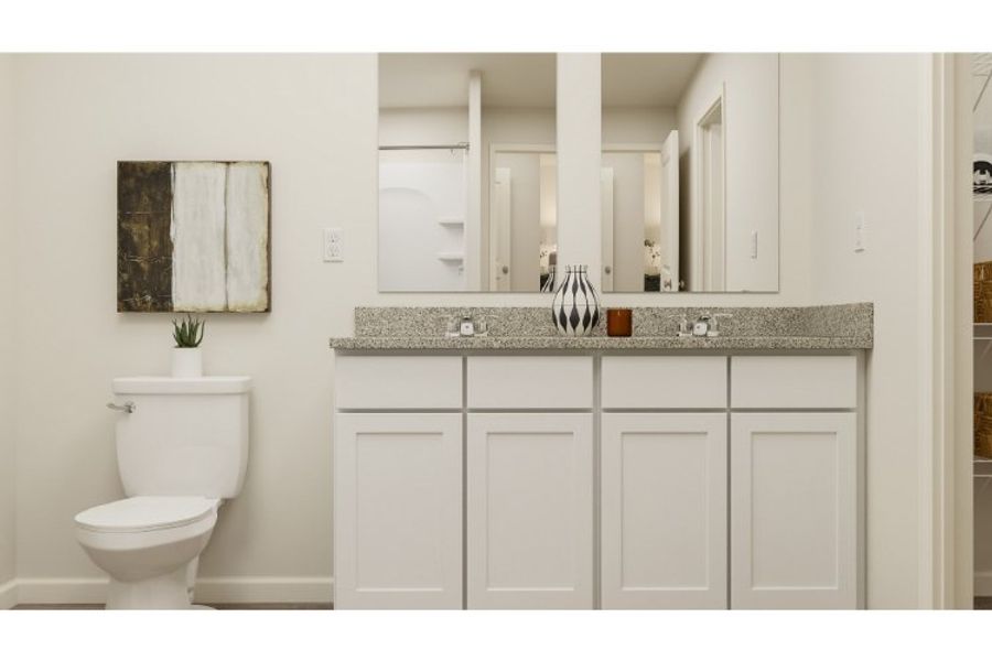 A bathroom with white cabinets.