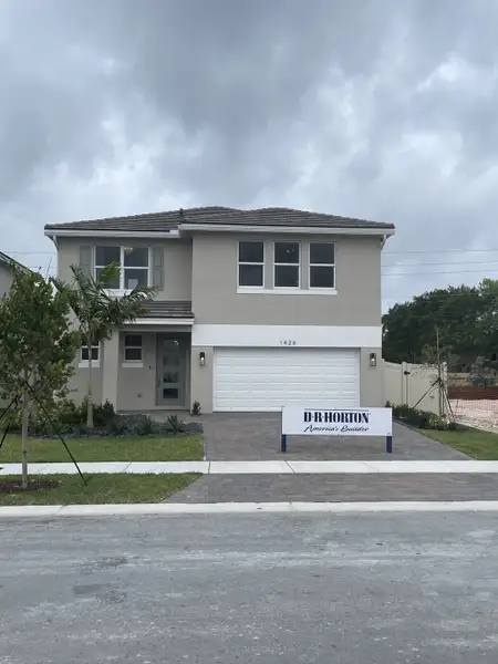 A modern two-story home with a landscaped yard in Parker Pointe by D.R. Horton (Homestead, FL).