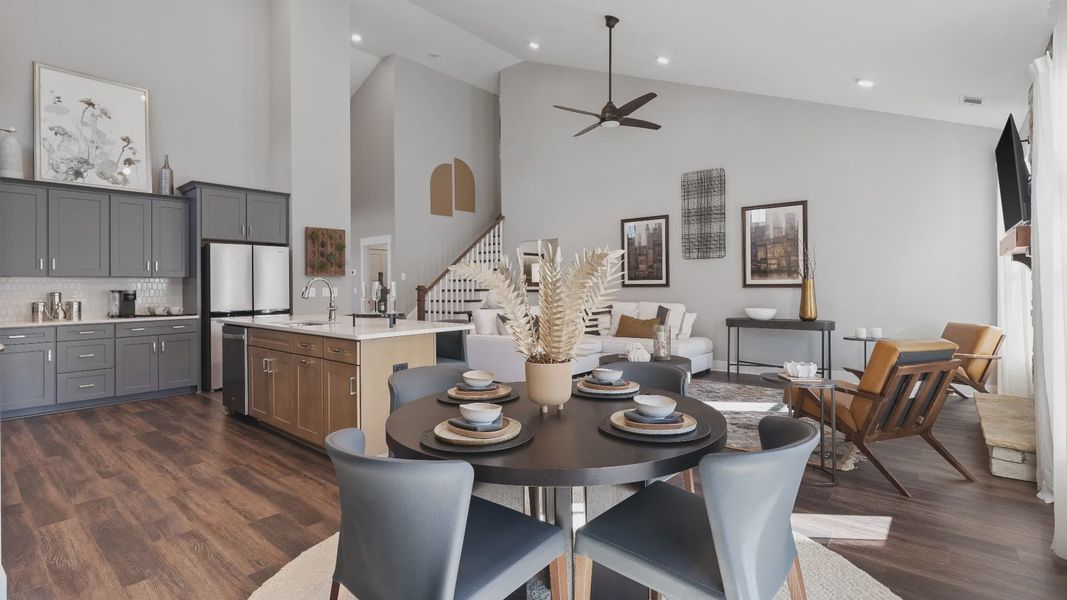 Elevated two-story ceiling open concept living spaces with hardwood flooring and large windows at Walnut Ridge by DRB Homes