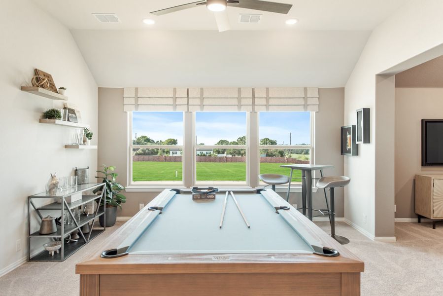 Game room with pool table, ceiling fan, and large windows overlooking a backyard lawn Game room with pool table, ceiling fan, and large windows overlooking a backyard lawn