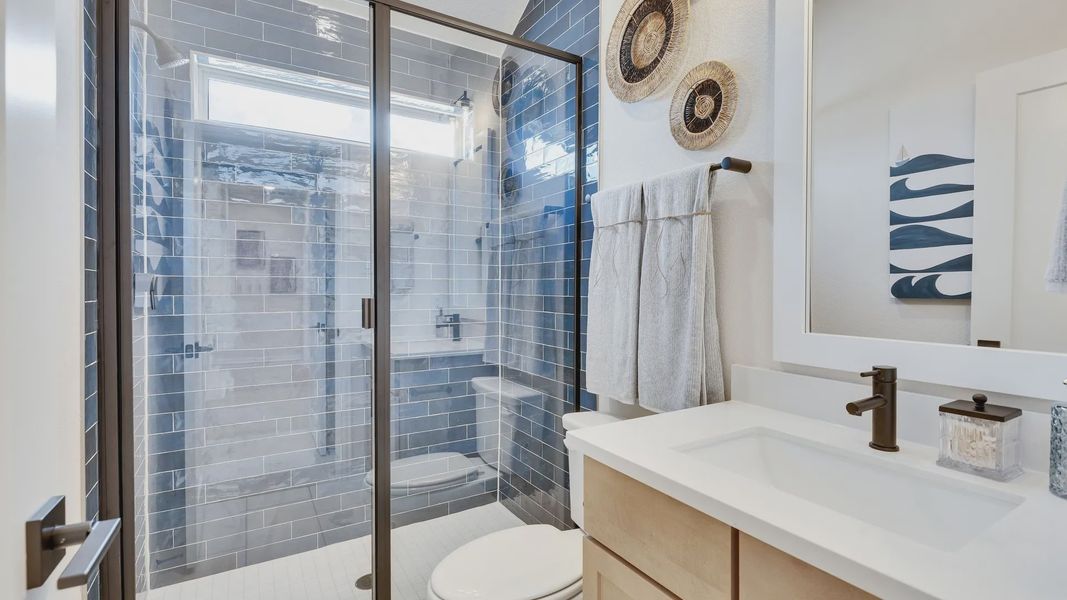 Experience opulent relaxation in this Sunfield bathroom, featuring elegant blue tile and refined wood cabinetry. Experience opulent relaxation in this Sunfield bathroom, featuring elegant blue tile and refined wood cabinetry.