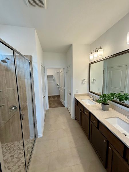 A modern bathroom features a dual-sink vanity, spacious glass shower, and elegant lighting for a luxurious touch. A modern bathroom features a dual-sink vanity, spacious glass shower, and elegant lighting for a luxurious touch.