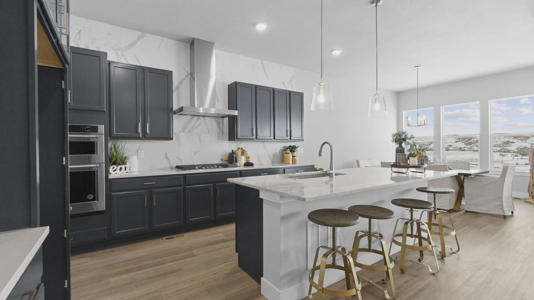 Sophisticated Montaine kitchen showcases marble surfaces, bespoke cabinetry, and expansive views through grand windows.