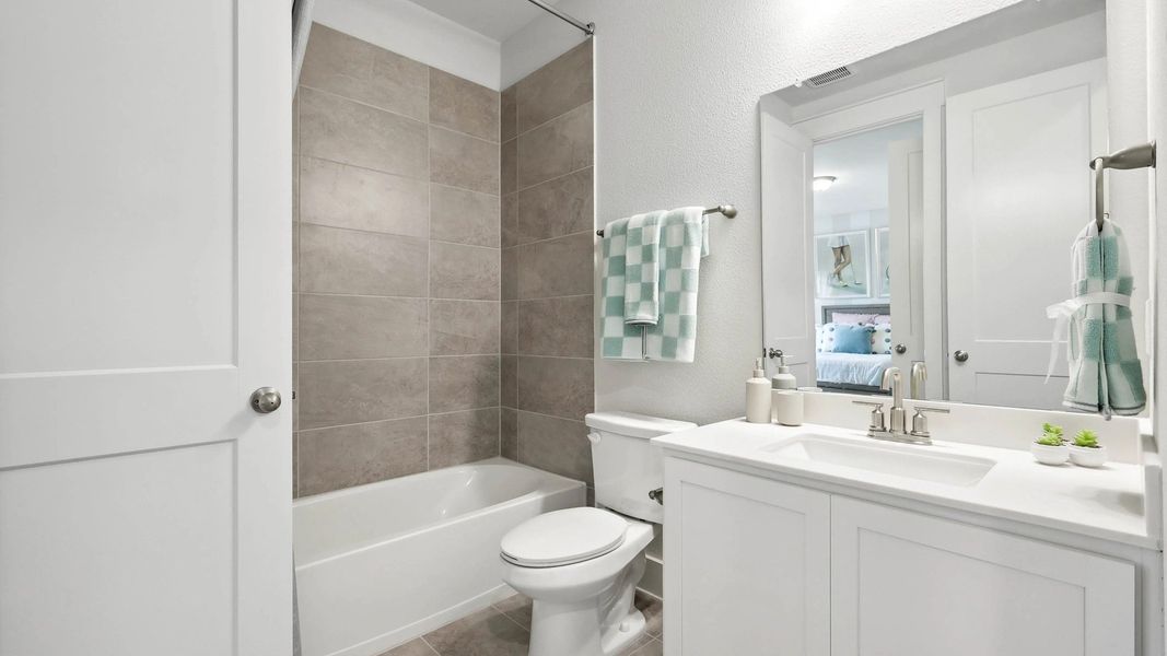 Elegant bathroom with sleek tile work, pristine white vanity, and polished fixtures in Collin Creek. Elegant bathroom with sleek tile work, pristine white vanity, and polished fixtures in Collin Creek.