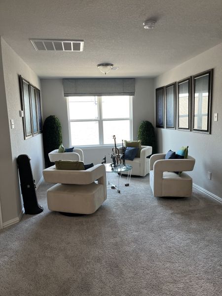 A cozy seating area with plush cream chairs, a glass table, and modern art, perfect for relaxing or conversation. A cozy seating area with plush cream chairs, a glass table, and modern art, perfect for relaxing or conversation.