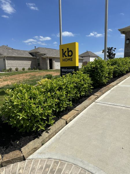 Charming brick homes in Bauer Meadow by KB Home, Hockley, TX, with lush landscaping and welcoming signage.