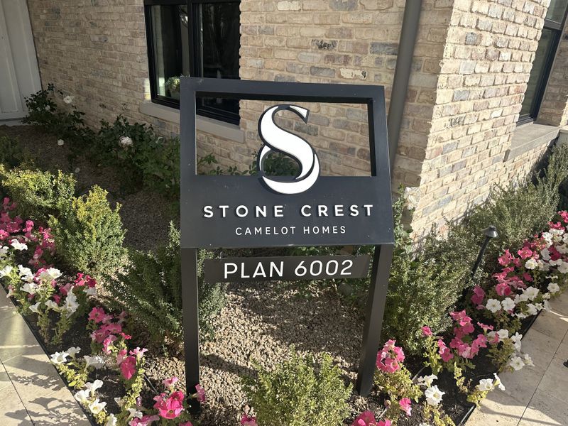Charming landscape with a floral border in Stone Crest by Camelot Homes, Gilbert, AZ, featuring a stylish brick exterior.