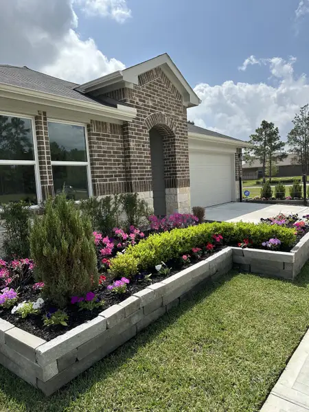 Charming brick home with a landscaped garden in Landing Meadows - Premier Series by Meritage Homes (New Caney, TX).