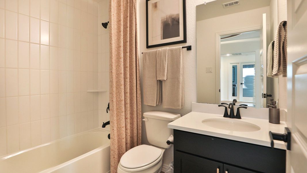 Embrace understated elegance in Bridgeland's bathroom, showcasing a black vanity paired with modern matte fixtures. Embrace understated elegance in Bridgeland's bathroom, showcasing a black vanity paired with modern matte fixtures.