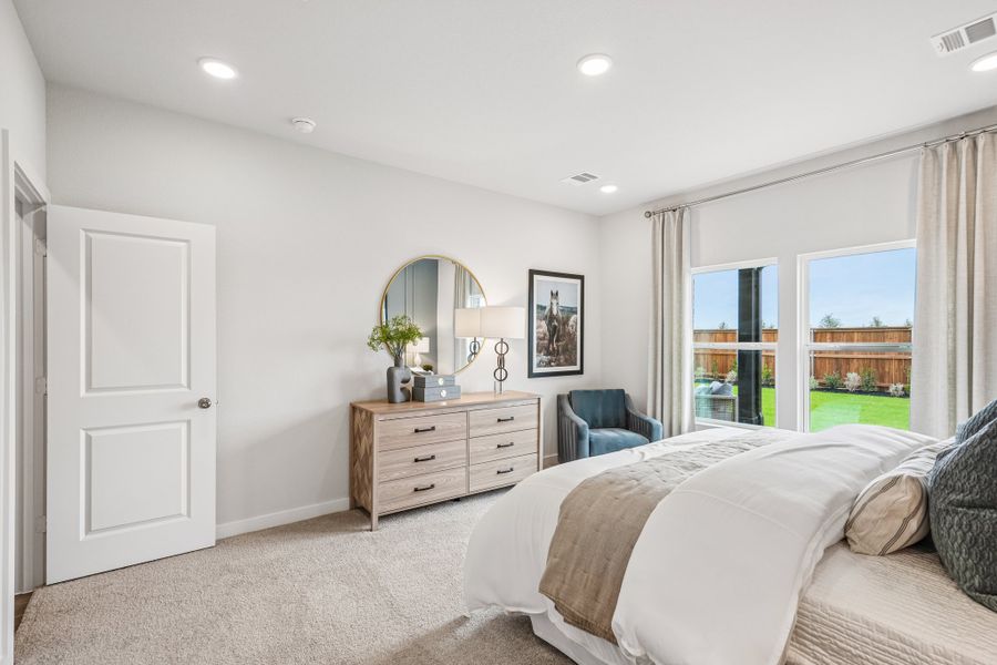 A bedroom with a bed and a mirror.