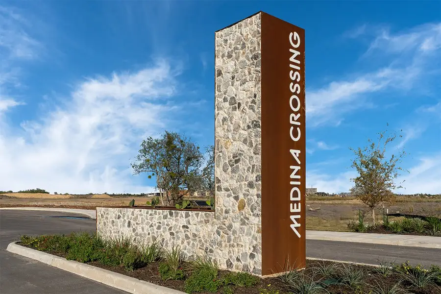 Entrance to the Medina Crossing - Villa Collection community in Von Ormy, TX, featuring signage and landscaping (Image 2).