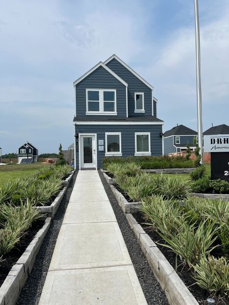 A charming blue home with manicured landscaping in Legacy Village by D.R. Horton (Houston, TX).