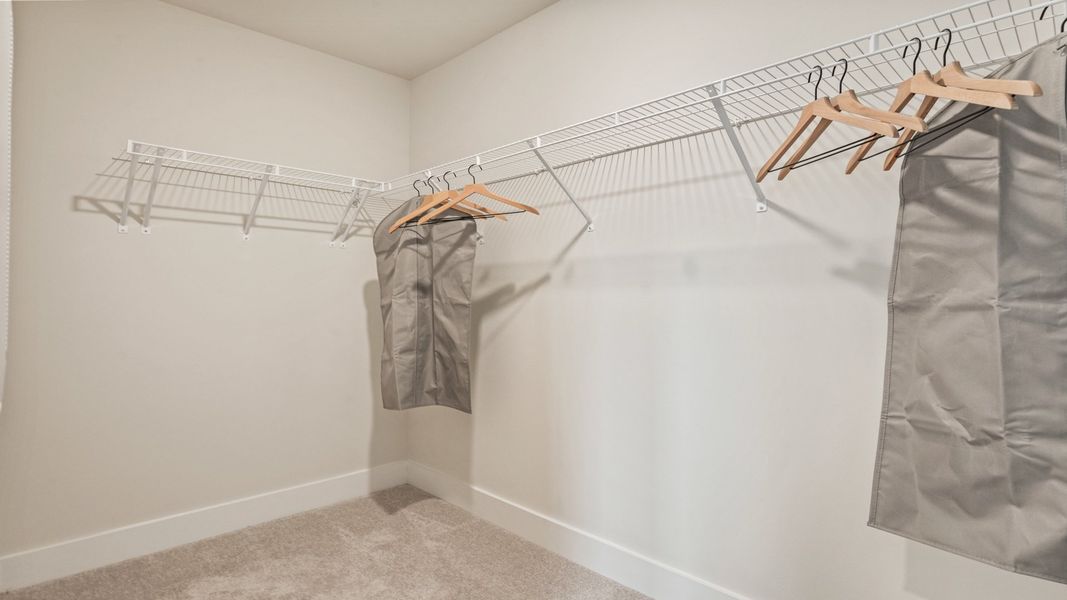 Spacious walk-in closet with built-in shelving in the primary suite