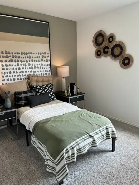 A chic bedroom featuring a stylish bed with green accents, modern artwork, and minimalist decor enhances a cozy space. A chic bedroom featuring a stylish bed with green accents, modern artwork, and minimalist decor enhances a cozy space.