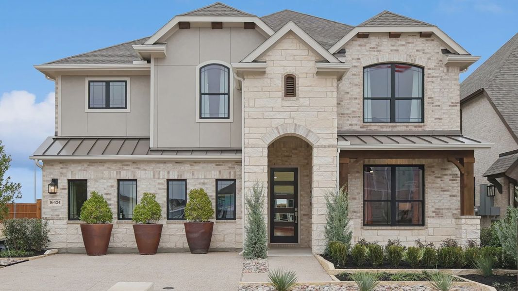 Elegant stone facade with arch entry and manicured landscaping at Wildflower Ranch. Elegant stone facade with arch entry and manicured landscaping at Wildflower Ranch.